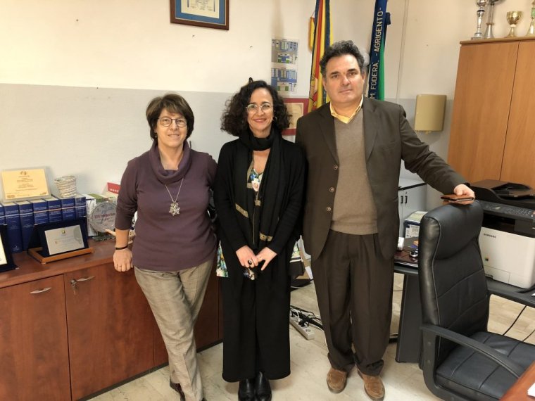 Three people pose in an office